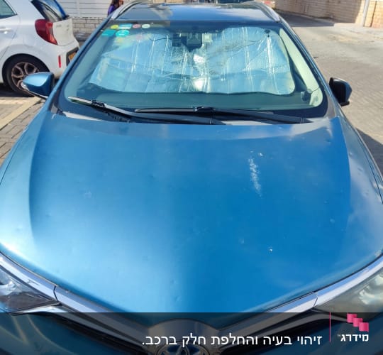 מכונית כחולה עם שמשה קדמית מכוסה